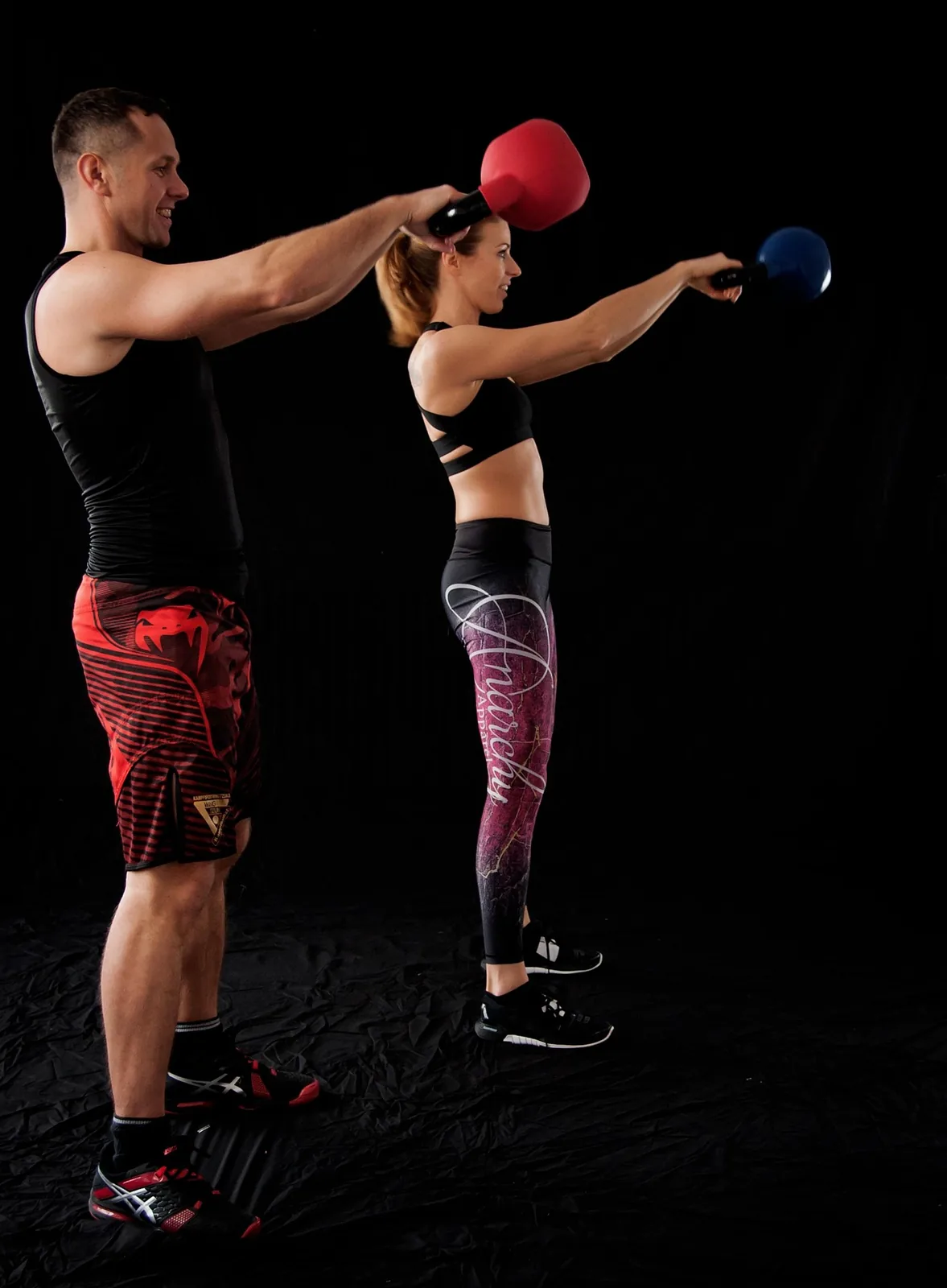 Two people doing kettlebell swings